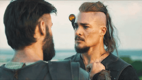 A Man With Long Hair And A Beard Stands Next To Another Man With Short Hair GIF
