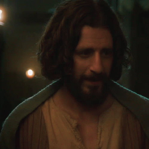 A Man With Long Hair And A Beard Wearing A Brown Shirt GIF