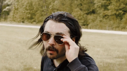 A Man With Long Hair And A Beard Wearing A Pair Of Sunglasses GIF