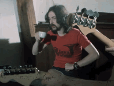 A Man With Long Hair And A Beard Wearing A Red Shirt That Says ' Jazz ' On It GIF