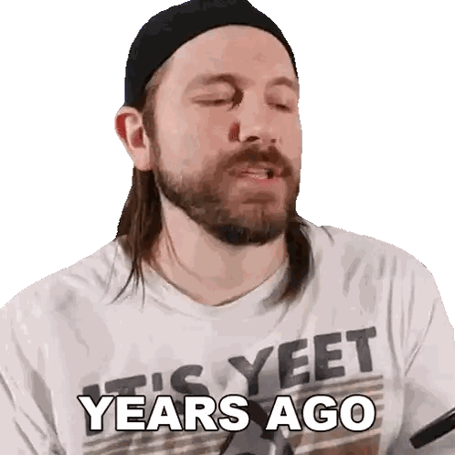 a man with long hair and a beard wearing a shirt that says yeet years ago