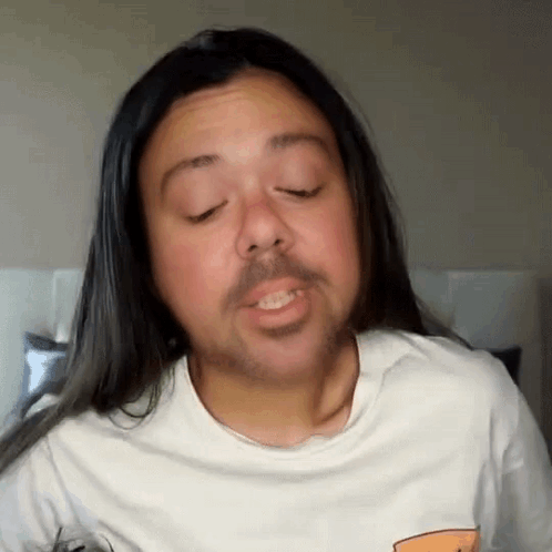 A Man With Long Hair And A Beard Wearing A White Shirt GIF