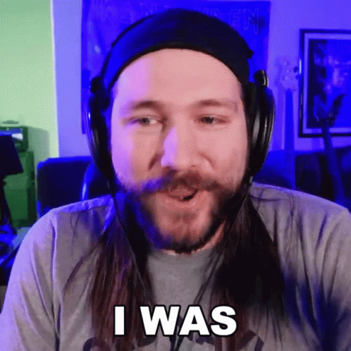 A Man With Long Hair And A Beard Wearing Headphones Says " I Was " GIF