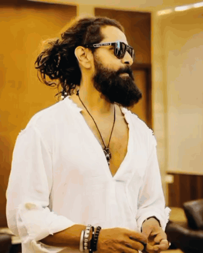 A Man With Long Hair And A Beard Wears A White Shirt And Sunglasses With The Word United On Them GIF