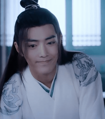 A Man With Long Hair And A Bun On His Head Is Wearing A White Kimono And Smiling . GIF