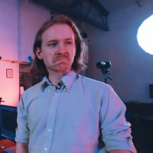 A Man With Long Hair And A Mustache Is Making A Sad Face GIF