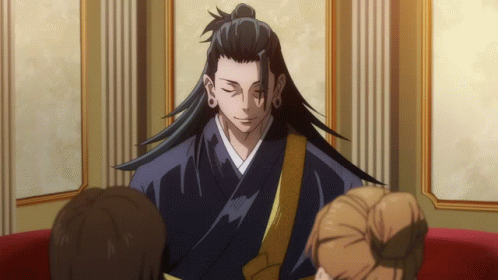 A Man With Long Hair And A Ponytail Is Sitting In A Room With Other People GIF