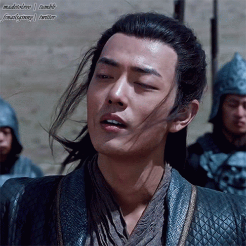 A Man With Long Hair And A Ponytail Is Standing In Front Of Soldiers GIF