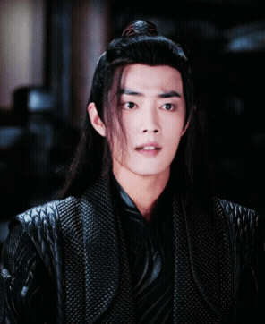 A Man With Long Hair And A Ponytail Is Wearing A Black Jacket GIF