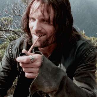 A Man With Long Hair And A Ring On His Finger Smoking A Pipe GIF