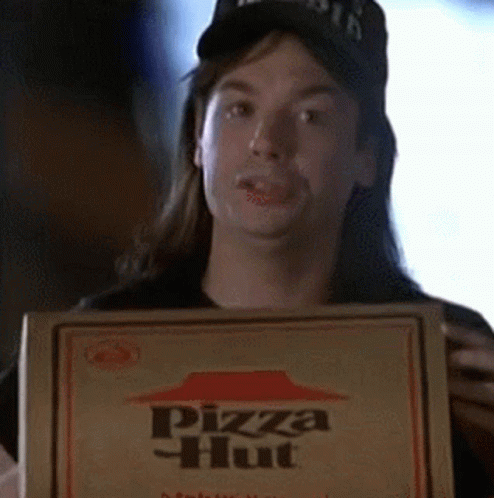 A Man With Long Hair Is Holding A Box Of Pizza Hut Pizza GIF