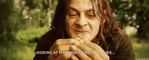 A Man With Long Hair Is Holding A Coin In His Hands . GIF