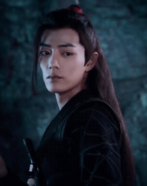 A Man With Long Hair Is Holding A Sword In His Hand GIF