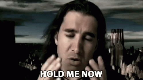 A Man With Long Hair Is Holding His Hands To His Face While Saying `` Hold Me Now '' . GIF