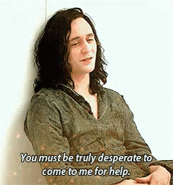 A Man With Long Hair Is Leaning Against A Wall And Saying You Must Be Truly Desperate To Come To Me For Help . GIF