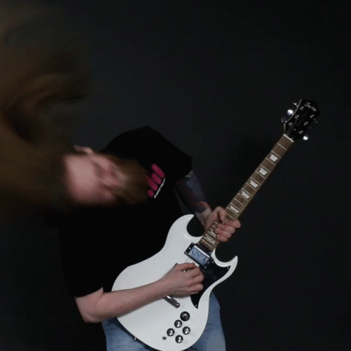 A Man With Long Hair Is Playing A White Guitar GIF