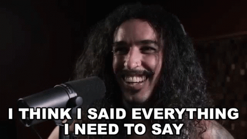 a man with long hair is singing into a microphone and says `` i think i said everything i need to say ''
