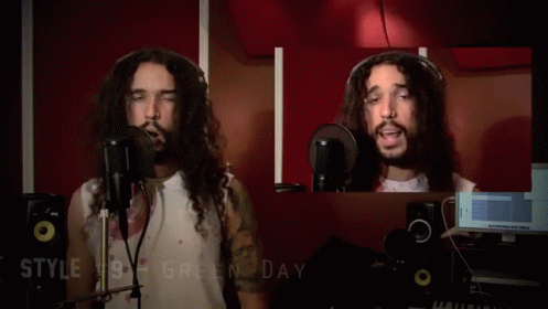 A Man With Long Hair Is Singing Into A Microphone With The Words Style # 10 Gregorian Chante Below Him GIF
