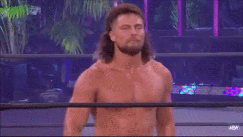 A Man With Long Hair Is Standing In A Wrestling Ring Without A Shirt On . GIF