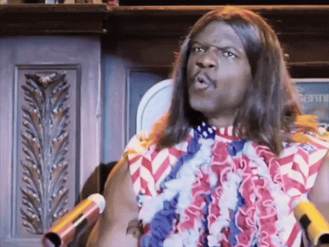 A Man With Long Hair Is Standing In Front Of A Microphone Wearing An American Flag Shirt GIF