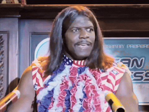 A Man With Long Hair Is Standing In Front Of A Sign That Says Sonny Propere GIF