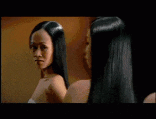 A Man With Long Hair Is Standing Next To Two Naked Women GIF