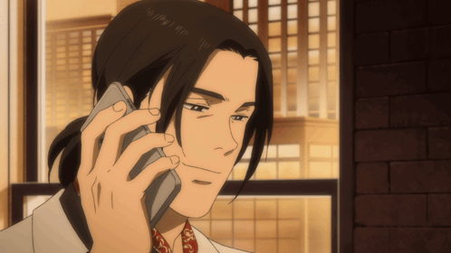 A Man With Long Hair Is Talking On A Phone GIF
