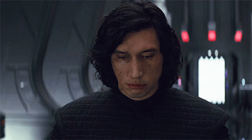A Man With Long Hair Is Wearing A Black Jacket And Looking At The Camera . GIF