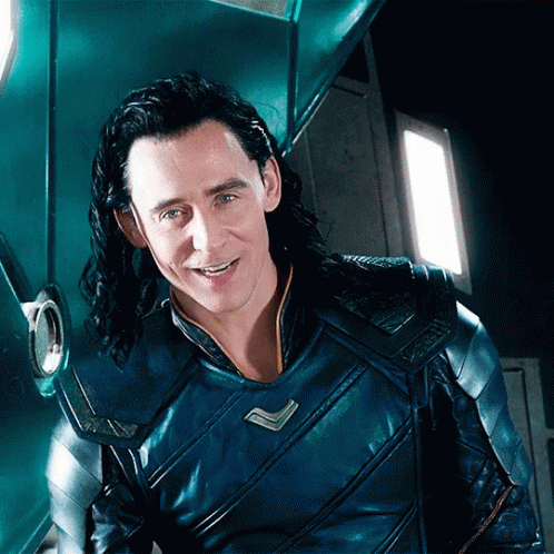 A Man With Long Hair Is Wearing A Blue Armored Jacket And Smiling . GIF