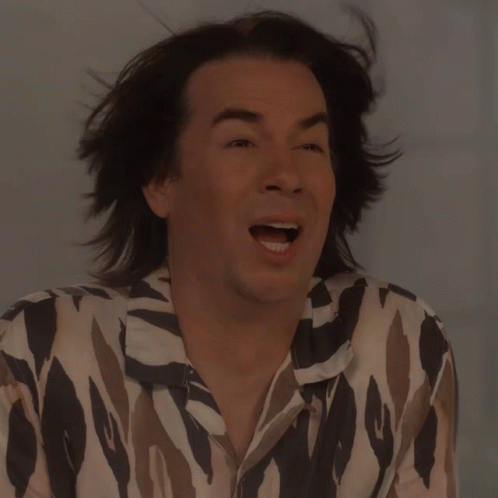 A Man With Long Hair Is Wearing A Shirt That Says ' Zebra ' On It GIF
