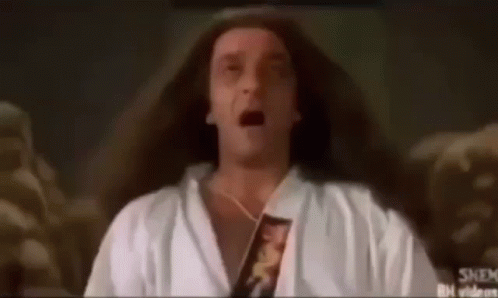 A Man With Long Hair Is Wearing A White Robe And Holding A Book In His Hand . GIF