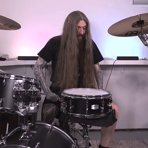 A Man With Long Hair Playing A Drum Set GIF