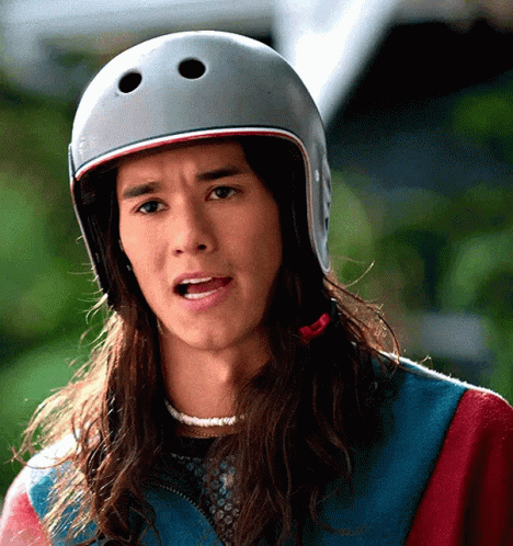A Man With Long Hair Wearing A Helmet Making A Funny Face GIF