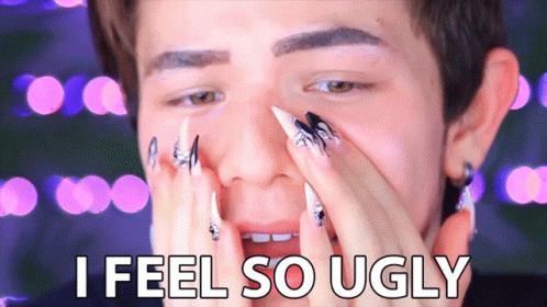 A Man With Long Nails Covering His Face And The Words I Feel So Ugly GIF
