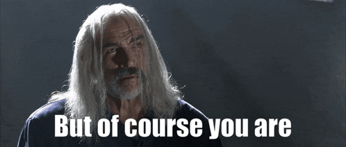 A Man With Long White Hair And A Beard Says " But Of Course You Are " GIF