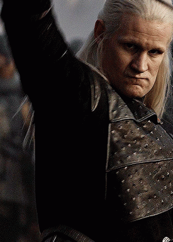 a man with long white hair is wearing a black leather jacket