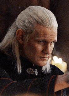 a man with long white hair is wearing a black top