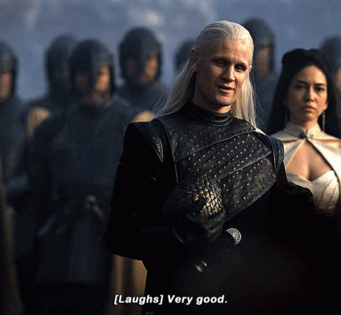 a man with long white hair says [ laughs ] very good in front of a group of people