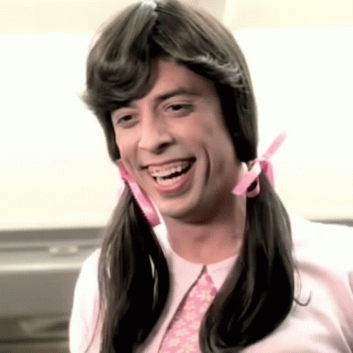 A Man With Pigtails And Braces Smiles For The Camera GIF
