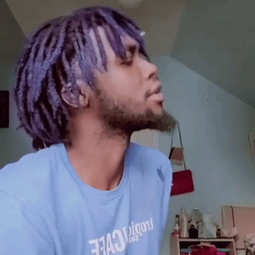 A Man With Purple Hair And A Beard Is Wearing A Blue Shirt That Says " 7143 " On It GIF