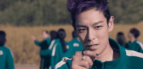 A Man With Purple Hair Is Pointing At Something GIF