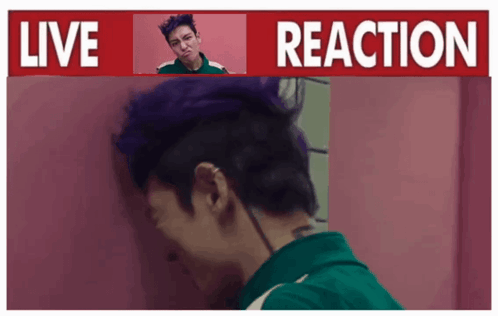 A Man With Purple Hair Is Standing In Front Of A Live Reaction Sign GIF