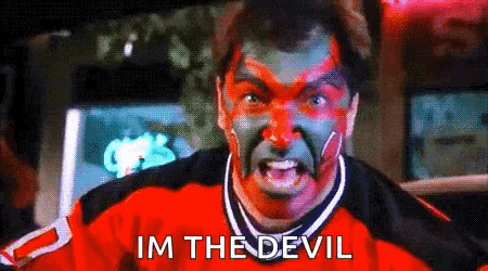 A Man With Red And Green Paint On His Face Has The Words Im The Devil Above Him GIF