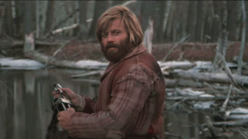 A Man With Red Hair And A Beard Is Holding A Camera In His Hand GIF