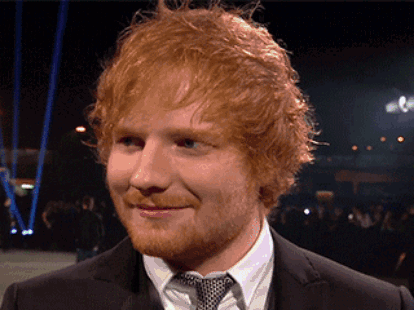 A Man With Red Hair And A Beard Is Wearing A Black Suit And Tie GIF