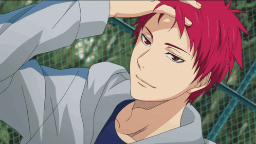 A Man With Red Hair And A Blue Shirt Is Standing In Front Of A Fence GIF