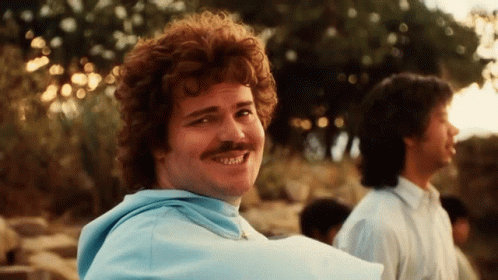 A Man With Red Hair And A Mustache Smiles For The Camera GIF