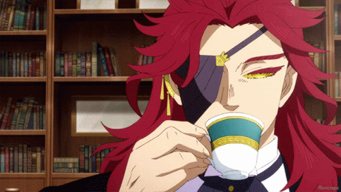 A Man With Red Hair Is Drinking From A Cup In Front Of Bookshelves GIF