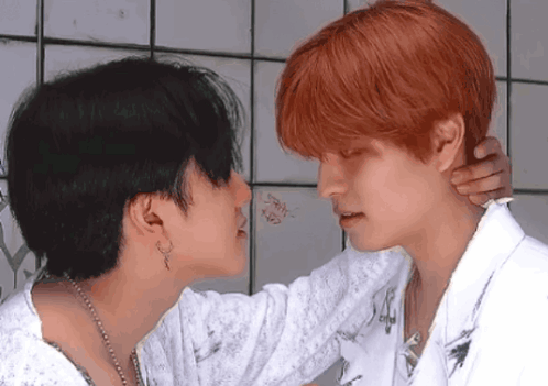 A Man With Red Hair Is Kissing A Woman With Black Hair GIF