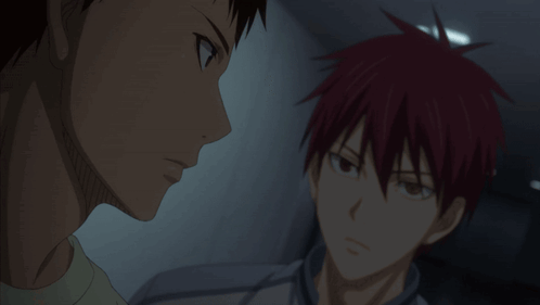 A Man With Red Hair Is Talking To Another Man In A Dark Room GIF